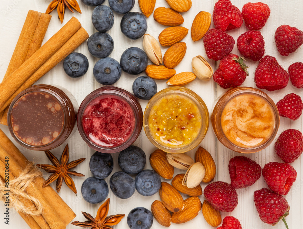 Jar of honey. Fruit honey with raspberries, blueberries, almonds and pistachios. Useful fortified jam for health and beauty. Honey cream. Vegetarian diet organic product. Copy space. Jar of honey. Fruit honey with raspberries, blueberries, almonds and pistachios. Useful fortified jam for health and beauty. Honey cream. Vegetarian diet organic product. Copy space.