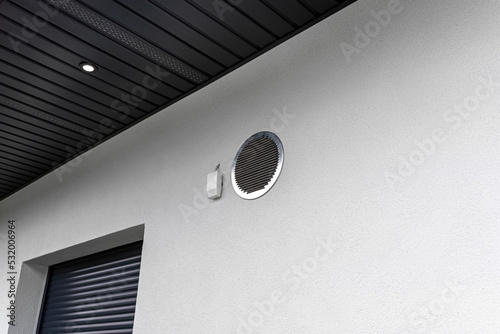 Air intake and exhaust in the wall of a single family house for mechanical ventilation with heat recovery, secured with a metal grill with mesh. photo