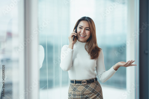 Smiling Asian businesswoman enjoying the phone, answering questions, talking to customers on the phone and comment in the office. Free Download Smiling Asian businesswoman enjoying the phone, answering questions, talking to customers on the phone and comment in the office. - GFXLoad