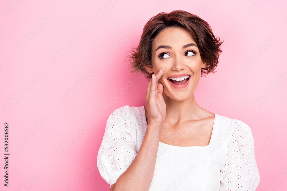 Photo portrait of lovely young girl hands cover mouth look sly empty space wear stylish white garment isolated on pink color background Photo portrait of lovely young girl hands cover mouth look sly empty space wear stylish white garment isolated on pink color background