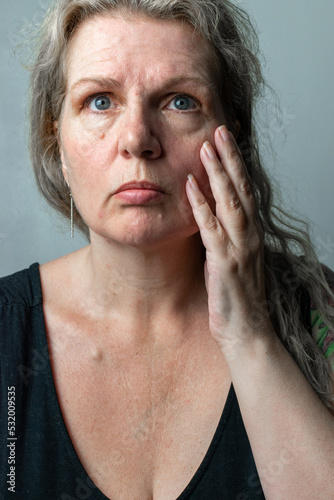 Valokuvatapetti old mature menopause age woman looking depressed about her wrinkled and ageing s