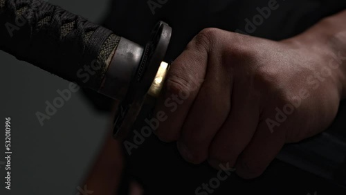 Japanese, black traditional kimano samurai, wars, touches sheath katana, runs fingers along sharp blade, braid handle. Kenjutsu national Japanese cultural identity historical traditions samurai studio