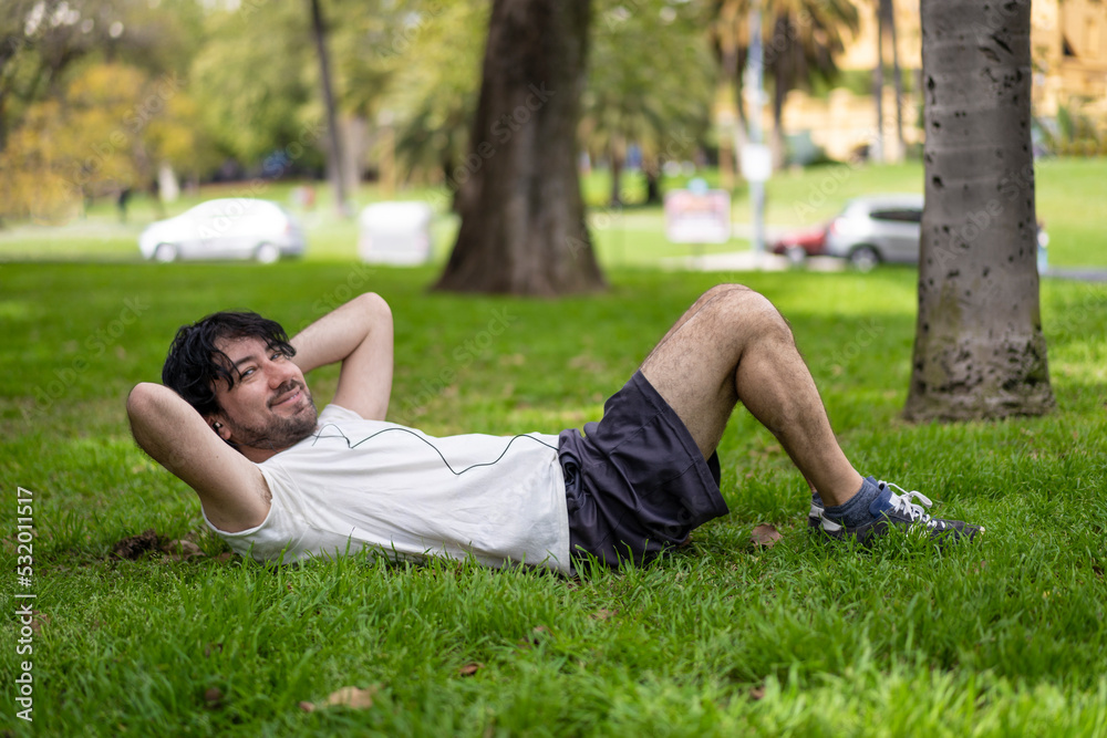 Portrait of handsome attractive mature bearded athletic latin man guy 40s doing sit-ups in the park. Portrait of handsome attractive mature bearded athletic latin man guy 40s doing sit-ups in the park.