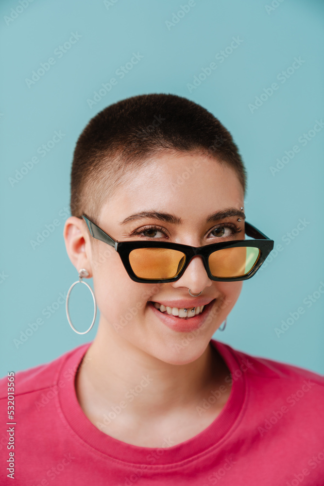 Young woman wearing sunglasses smiling and looking at camera Young woman wearing sunglasses smiling and looking at camera