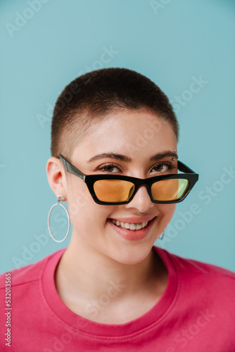 Young woman wearing sunglasses smiling and looking at camera