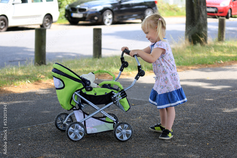 Kleines Mädchen mit Puppenwagen Kleines Mädchen mit Puppenwagen