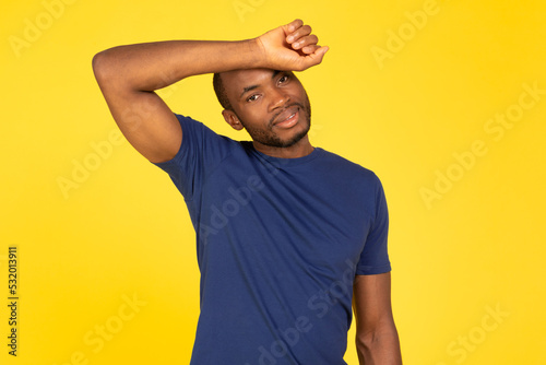 Sporty African American Man Wiping Sweat From Forehead, Yellow Background
