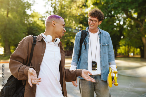 Two young handsome smiling stylish boys talking to each other photo