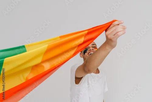 Obraz Portrait of young handsome smiling happy boy waving LGBT flag