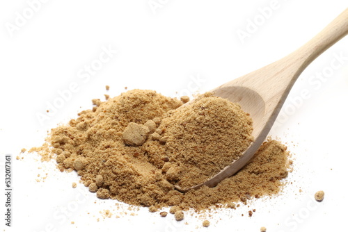 Unrefined cane sugar pile in wooden spoon isolated on white