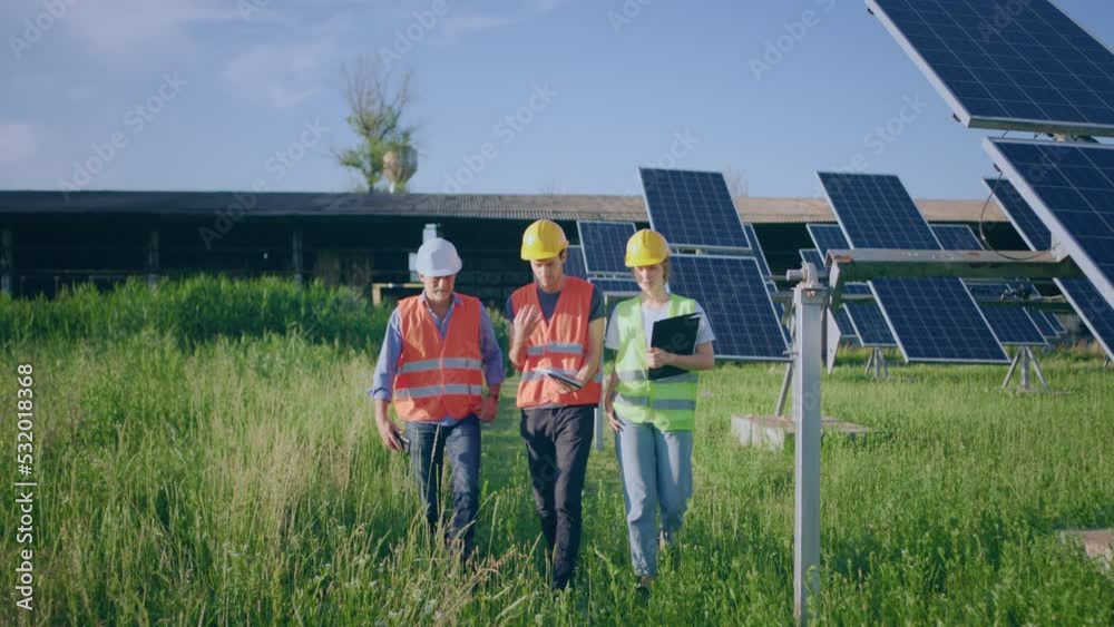 In front of the camera young ecological engineer woman together with two investors they analysing the plan of work concept of renewable energy ecological innovation In front of the camera young ecological engineer woman together with two investors they analysing the plan of work concept of renewable energy ecological innovation