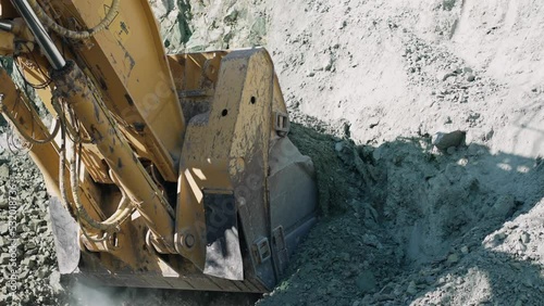 Excavator digger digging limestone in open pit mine. Development opencast for mining minerals. Mining excavator with electric shovel, slow motion