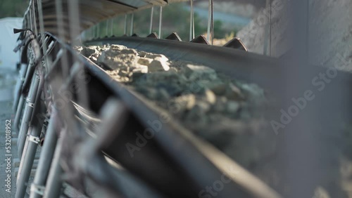 Close up of mine ore rocks being moved on a conveyor belt, slow motion