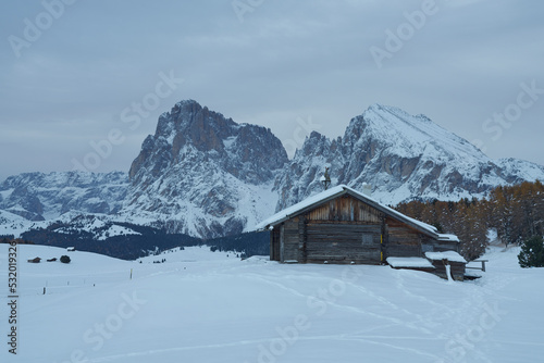 Cottage in the snow with mountains in the background