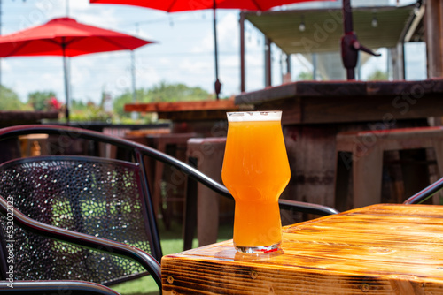 Φωτογραφία A tall glass of cold craft beer with a thick head of white froth