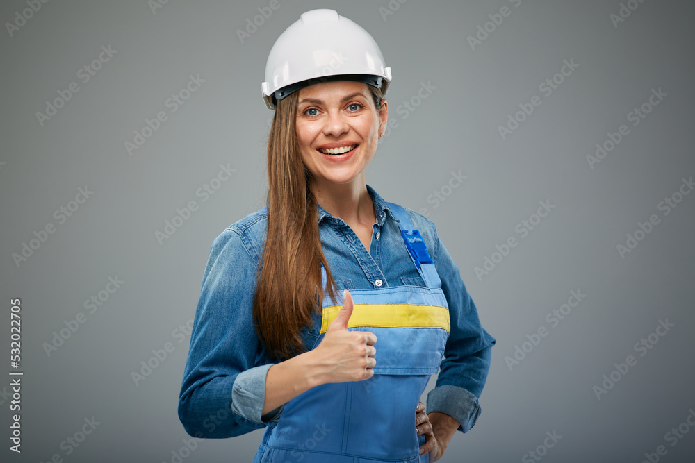 Smiling woman builder wearing safety industrial helmet and overall. Isolated female portrait.