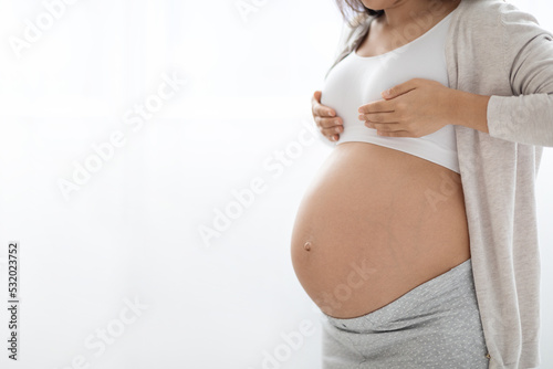 Unrecognizable pregnant woman having painful feelings in breast, copy space