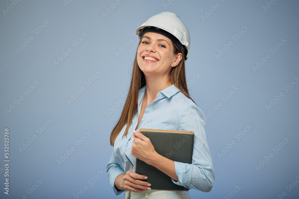 Woman architect or engineer in safety industrial helmet holding book. Isolated female portrait.