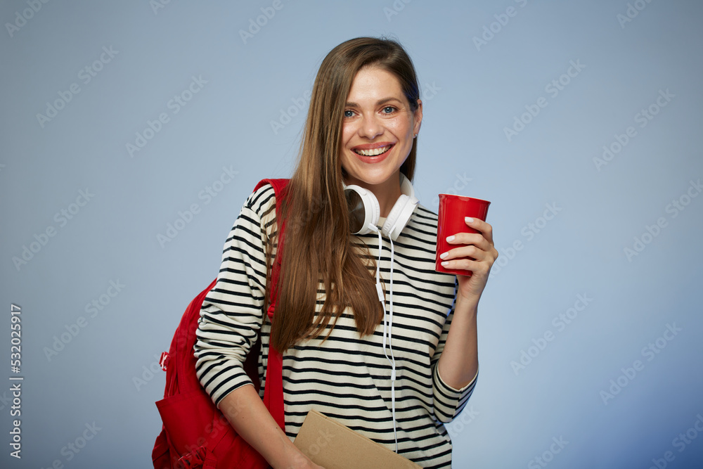 Young adult student millennial woman with book and red backpack holding red coffee cup. Isolated female portrait. Young adult student millennial woman with book and red backpack holding red coffee cup. Isolated female portrait.