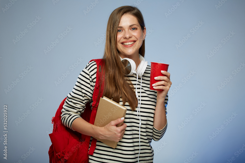 Young adult student millennial woman with book and red backpack holding red coffee cup. Isolated female portrait. Young adult student millennial woman with book and red backpack holding red coffee cup. Isolated female portrait.