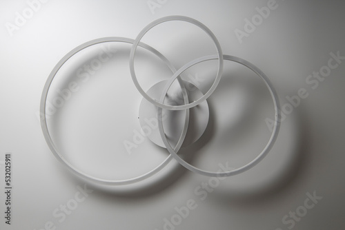 Chandelier in the form of three rings against a white ceiling