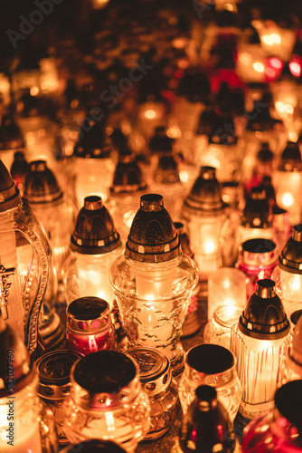 lit candles (lanterns) in the cemetery decorating graves during the Polish All Saints Day on November 1. Evening. Night. Blurred background. All Souls' Day.