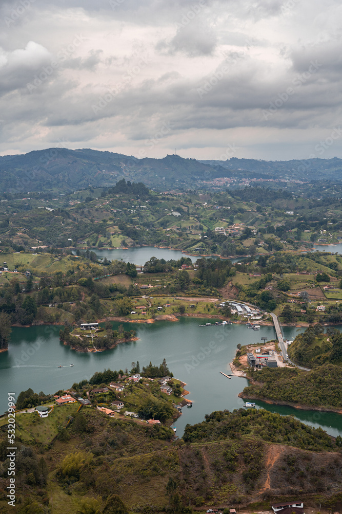 Aerial shot of the Guatape town in Columbia with mountains and clouded sky in the background