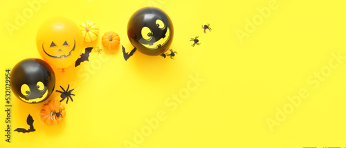 Composition with Halloween decor and balloons on yellow background with space for text, top view