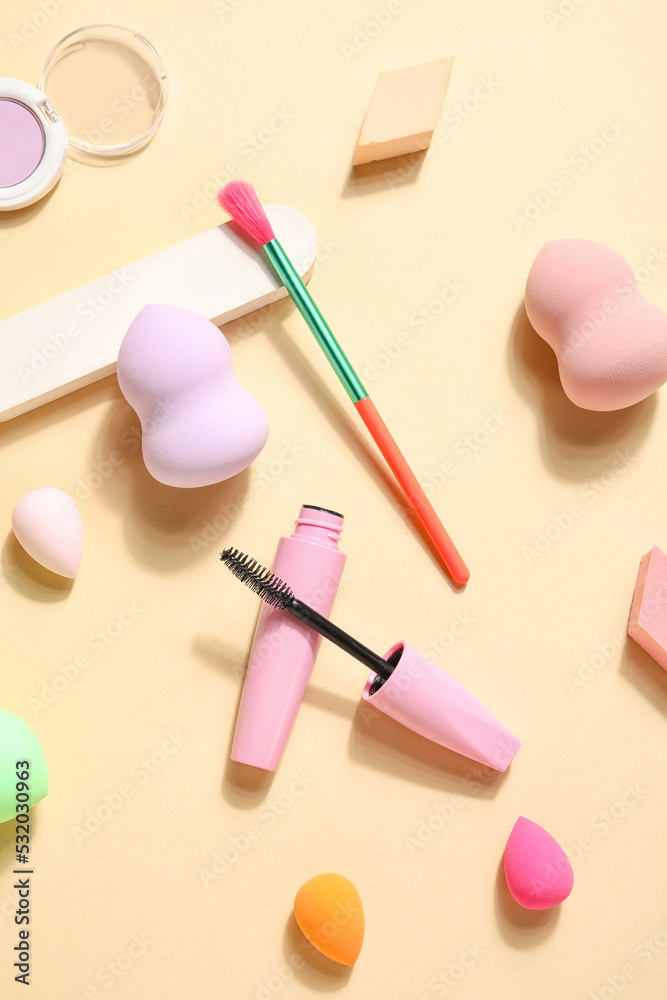 Makeup sponges with brush and decorative cosmetics on beige background Makeup sponges with brush and decorative cosmetics on beige background
