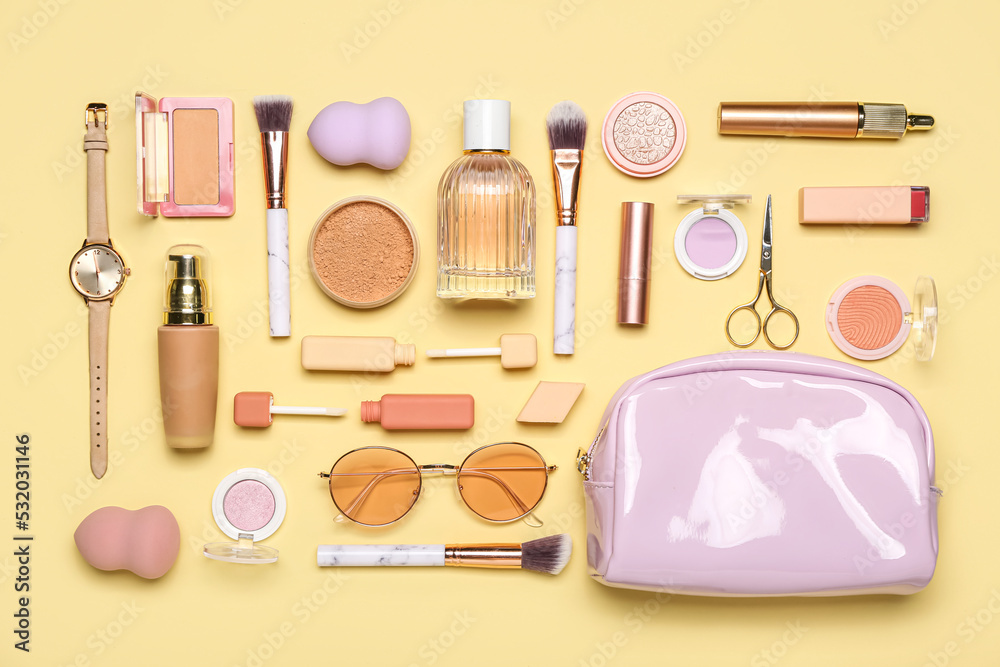 Cosmetic bag with makeup products and accessories on beige background