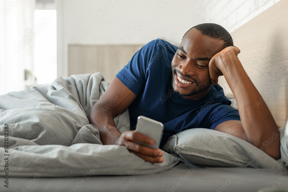Black Guy Texting On Cellphone Browsing Internet Lying In Bedroom Black Guy Texting On Cellphone Browsing Internet Lying In Bedroom