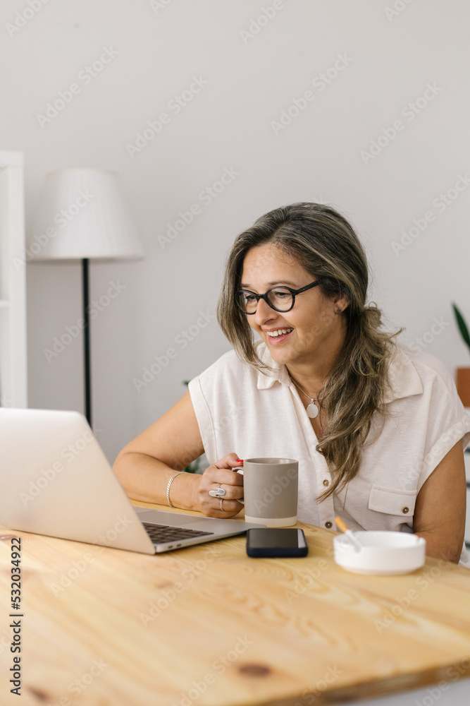 Mature woman working online from home via laptop Mature woman working online from home via laptop