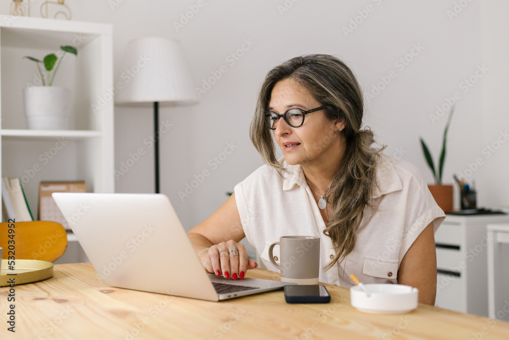 Mature woman working online via computer from home Mature woman working online via computer from home