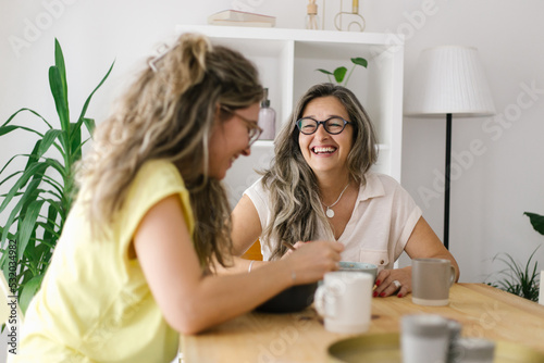 Happy mother and daughter sitting and laughing together