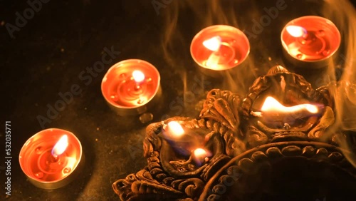 Side view of candles or diyas, Deepawali lights at night. Dark background stock footage. photo