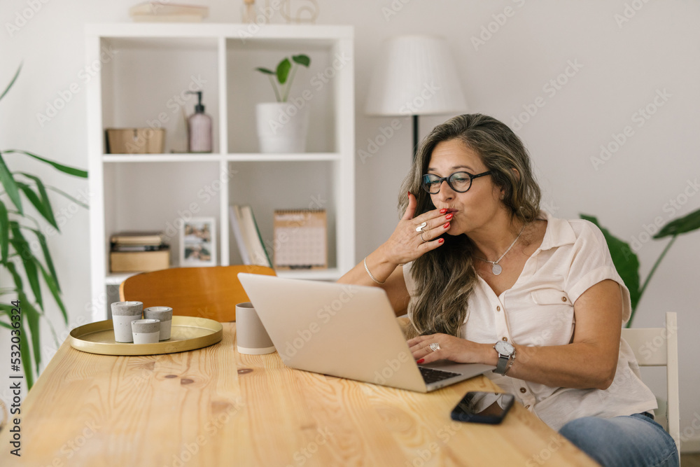 Happy woman video chatting via computer indoor. Happy woman video chatting via computer indoor.