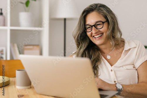 Happy woman having online meeting on laptop at home.