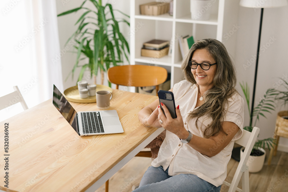 Happy woman face timing via smartphone at home Happy woman face timing via smartphone at home