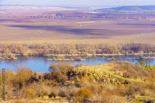 Beautiful view of the hilly valley with the river soothing winter nature. Background with copy space