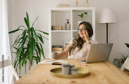 Wistful woman working remote from home office