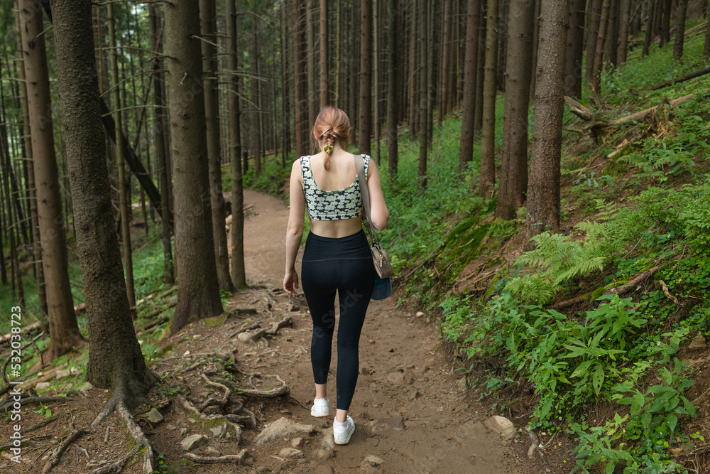 Woman traveler explorer with backpack hiking to the top of the mountain. Adventure weekend. Back view Woman traveler explorer with backpack hiking to the top of the mountain. Adventure weekend. Back view
