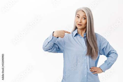 Bild auf Leinwand Surprised old asian lady, mother with gray hair, pointing at herself with disbel