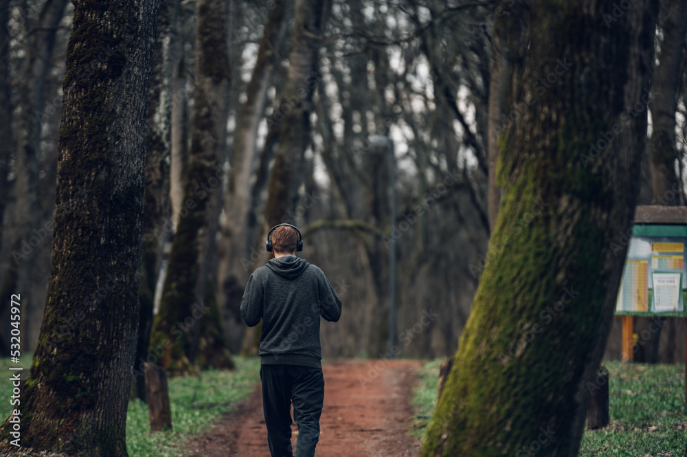 Young redhead man running in forest Young redhead man running in forest