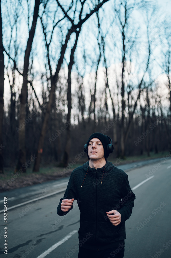 Redhead young man running outside on a mountain road Redhead young man running outside on a mountain road