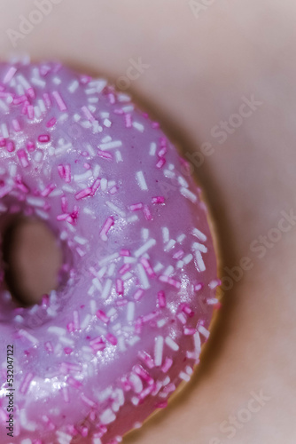 The Fully Close-up Of The Donut With Violet Icing And Colored Sprinkles. top View. Tasty delicious fat high calories sweet food. Selective Focus. favorite childhood treat. Advertising, banner.