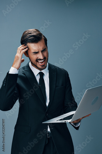 Man business tired stressed out staring at laptop pain head angry and working online via internet in business suit video call business talks on blue background copy place