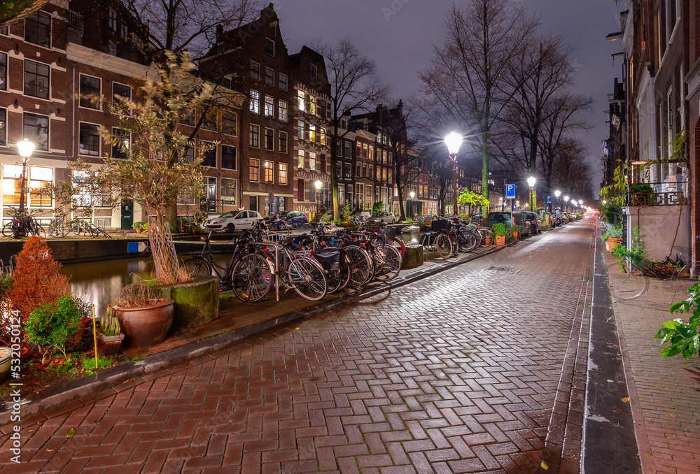 Beautiful old houses on the city waterfront of Amsterdam at sunset.