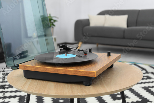 Vinyl record player on wooden table indoors. Interior element