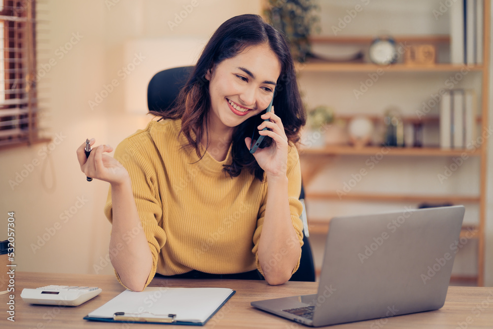 Asian business woman have the joy of talking on the phone, laptop and tablet on the office desk. Asian business woman have the joy of talking on the phone, laptop and tablet on the office desk.
