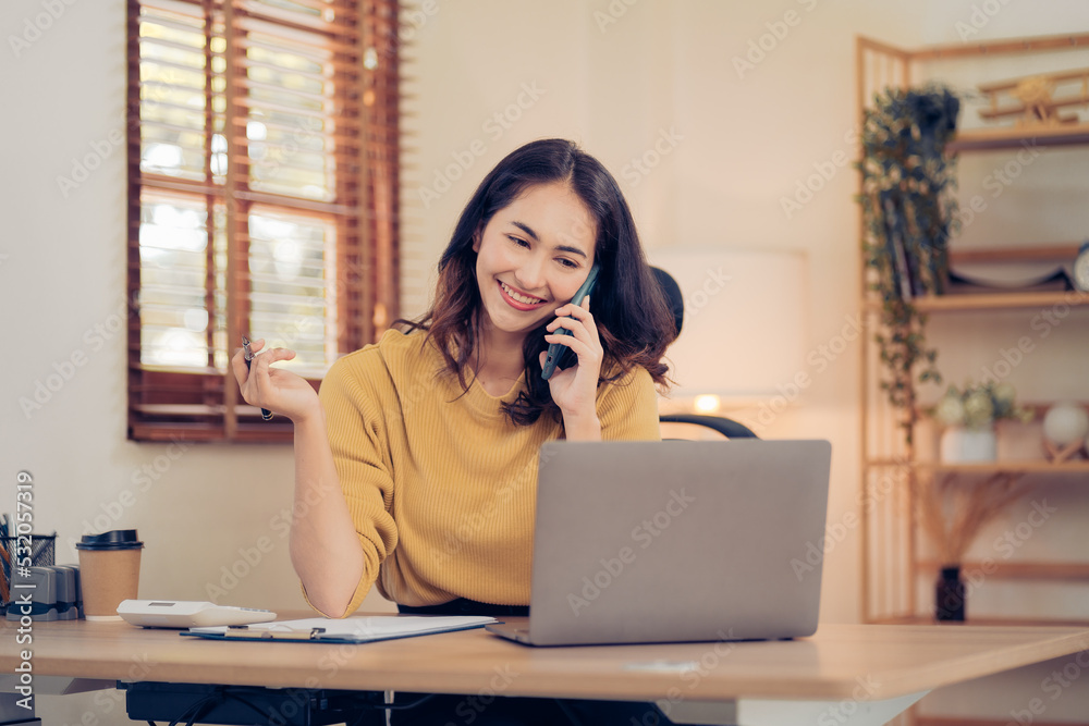 Asian business woman have the joy of talking on the phone, laptop and tablet on the office desk. Asian business woman have the joy of talking on the phone, laptop and tablet on the office desk.